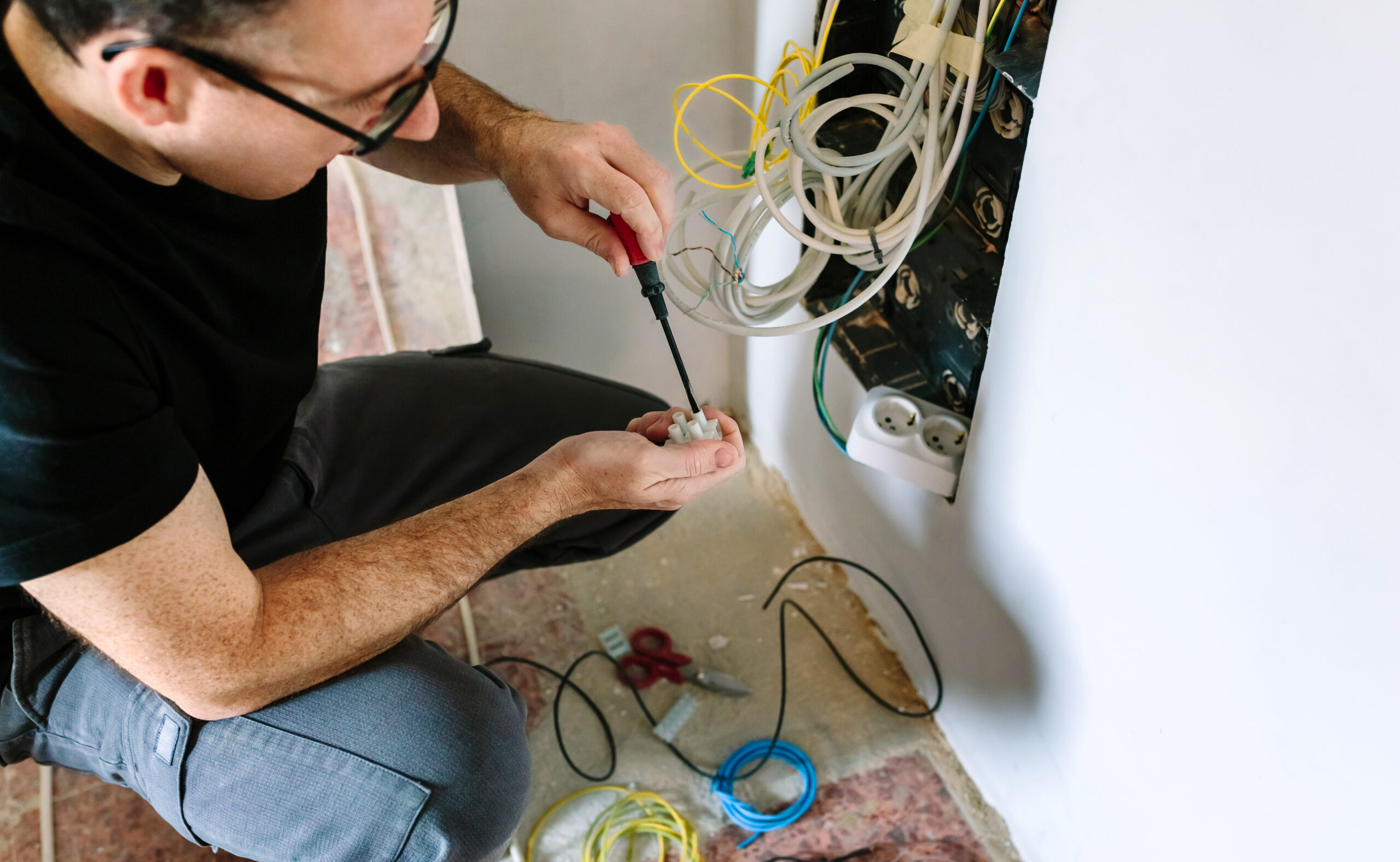 Closeup of an electrician working on electrical system in home.