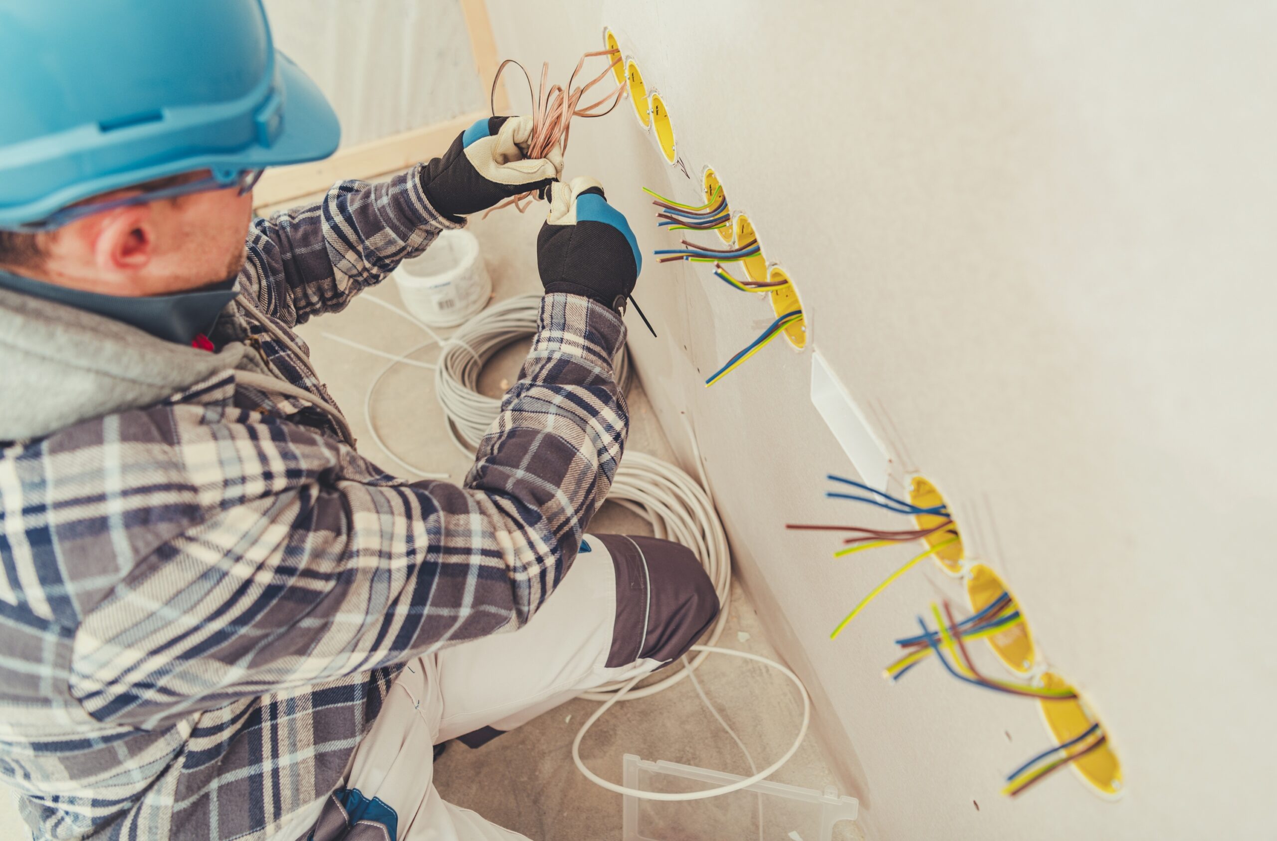 Electrician performing safe electrical installation in a residential setting.