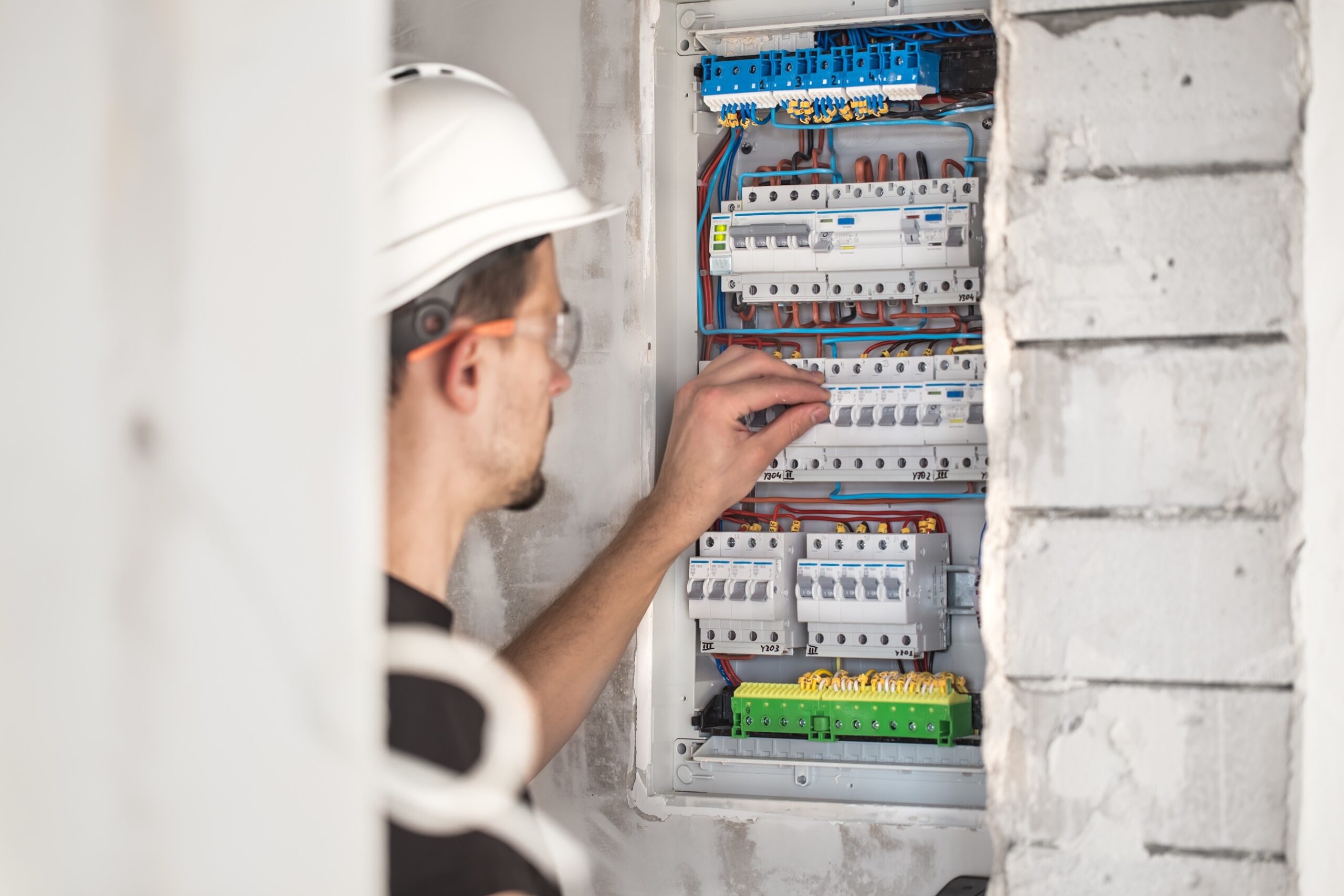 An image showing a circuit breaker box being inspected for faulty electrical repairs.